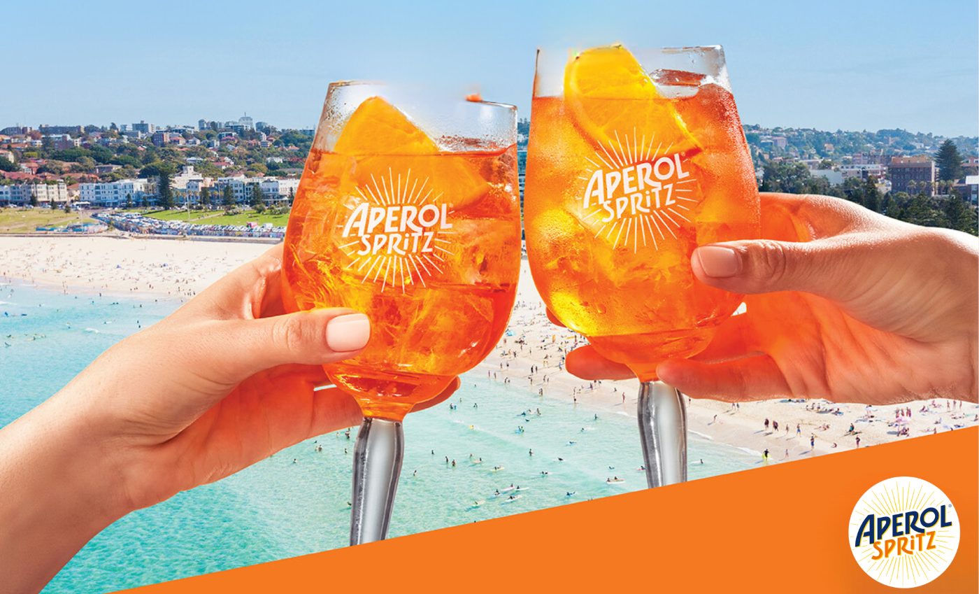 Image of 2 hands cheering with Aperol Spritz